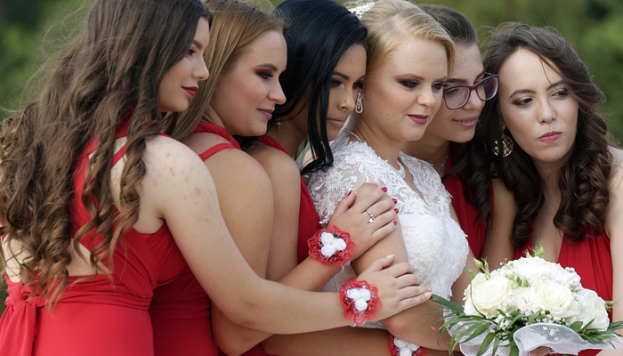 Bridesmaids wear matching color dresses
